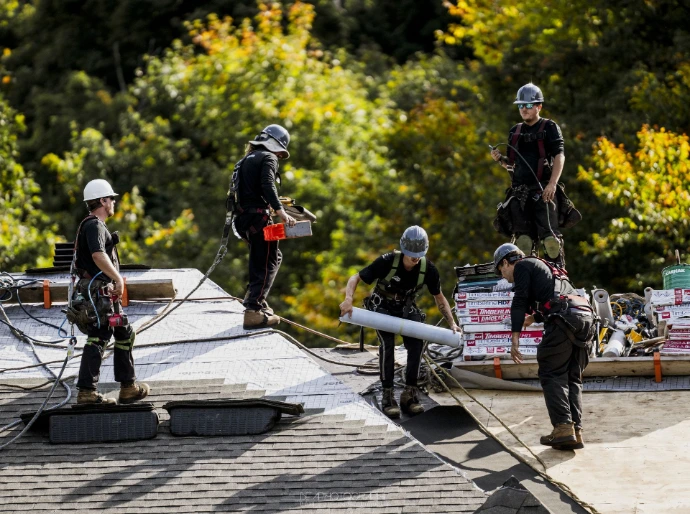 Couvreurs en action sur un chantier de toiture résidentielle.